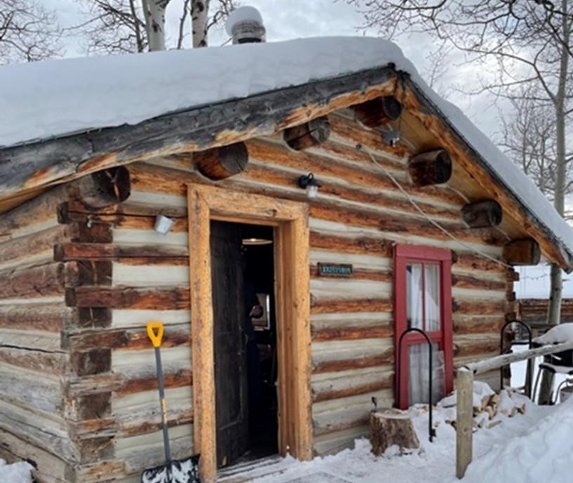 photo of a snow-covered log cabin